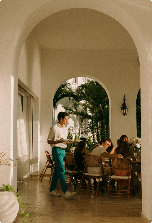 Arched stone terrace overlooking a Mediterranean coastline at golden hour