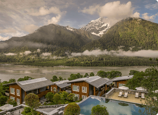 Remote mountain lodge framed by alpine peaks and morning mist