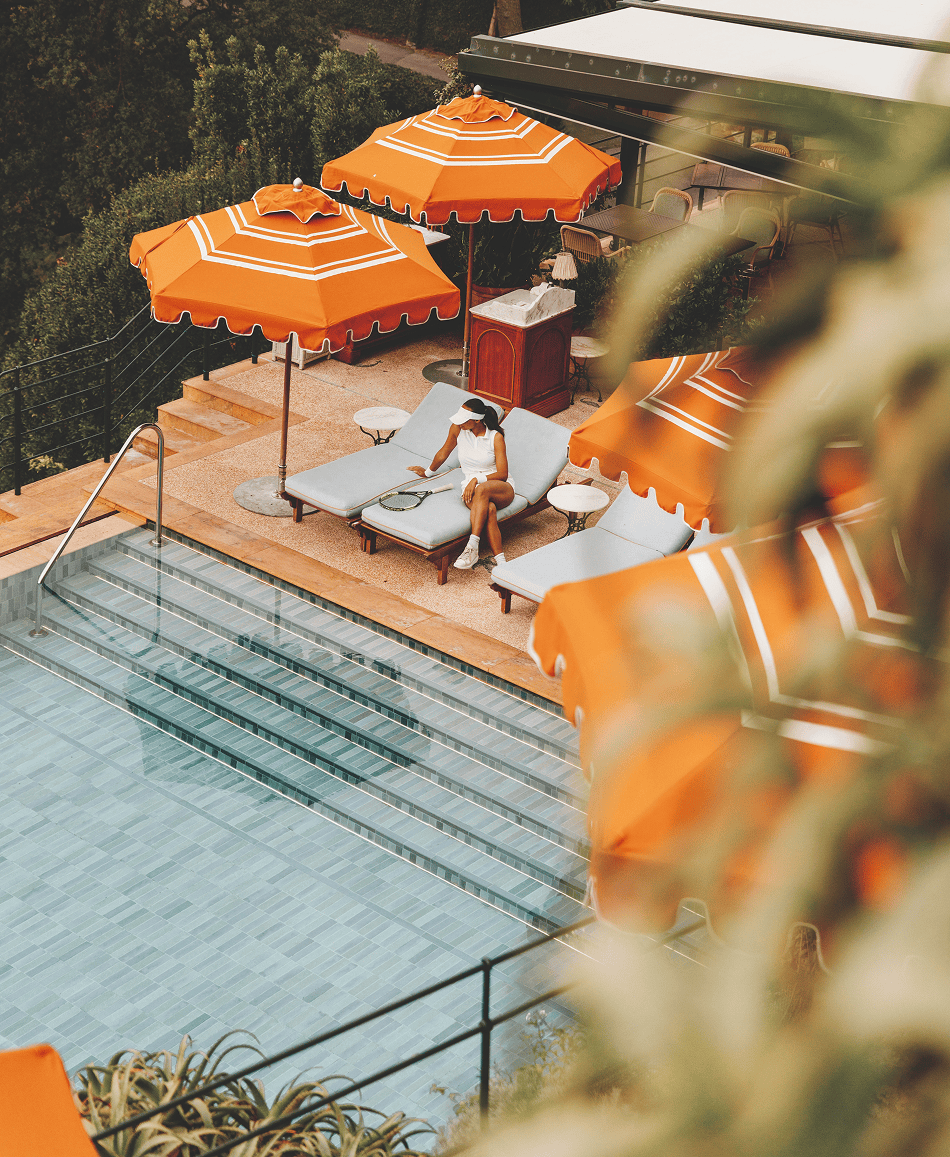Orange and white striped poolside umbrellas under a clear sky